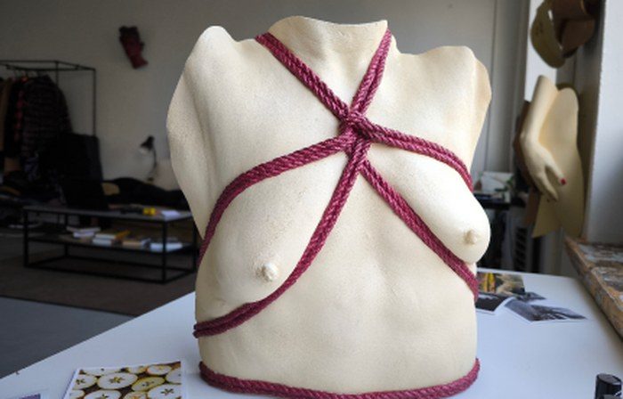 Bare cream life-cast torso crossed by a crimson cord, Athens Series