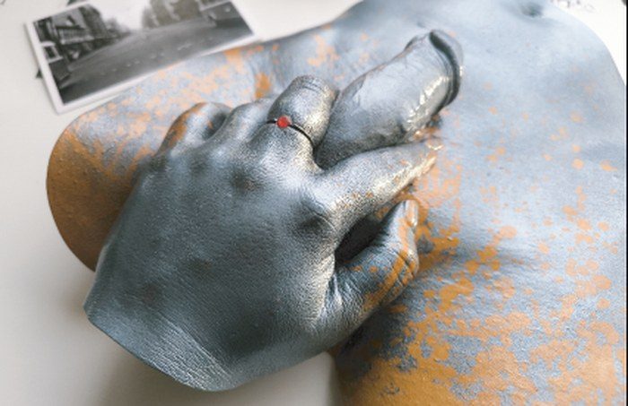 Brushed silver life cast of a hand resting on a chest, Rome Series